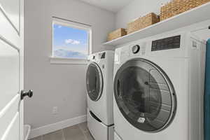 Laundry area featuring washer and dryer and tile patterned flooring