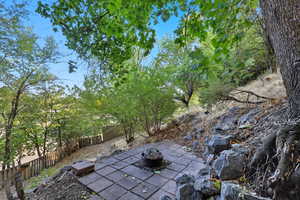 Fenced backyard featuring a fire pit and a patio