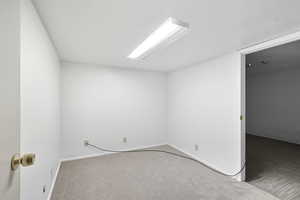 Carpeted empty room featuring baseboards