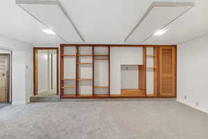 Unfurnished bedroom with light colored carpet and baseboards