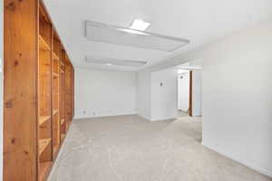 Empty room featuring light carpet and baseboards