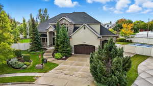 French country style house with stone siding, stucco siding, a garage, and driveway