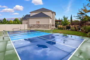 View of tennis court with a patio, a pergola, and a mountain view