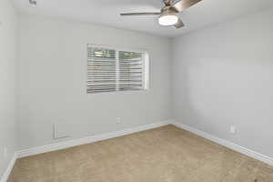 Spare room featuring carpet flooring and ceiling fan