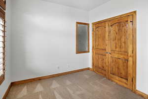 Unfurnished bedroom with baseboards and carpet