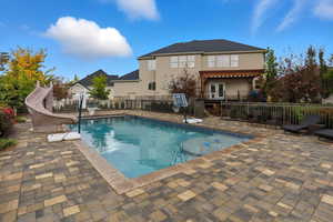 View of swimming pool with a patio area and a water slide