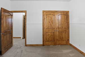 Unfurnished bedroom with light carpet and wainscoting