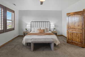 Carpeted bedroom with a ceiling fan and baseboards