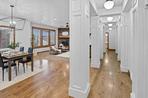 Hall featuring light wood-style flooring, recessed lighting, and a chandelier