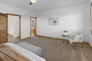 Carpeted bedroom featuring a ceiling fan and ensuite bathroom