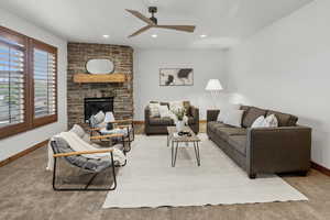 Carpeted living room with a fireplace, recessed lighting, and ceiling fan