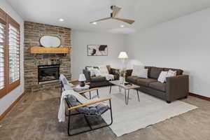 Carpeted living area featuring a fireplace, recessed lighting, and ceiling fan