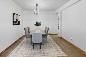 Dining area featuring carpet flooring and a chandelier