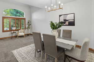 Dining area with light carpet and a chandelier
