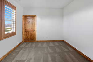 Empty room with carpet and baseboards