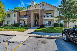 View of property featuring stairway and uncovered parking