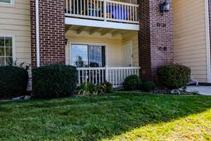 Property entrance featuring brick siding and a lawn
