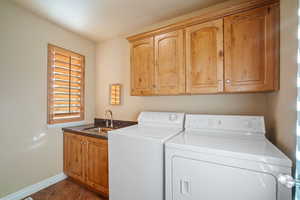 Laundry area with cabinet space, sink, washer and clothes dryer.