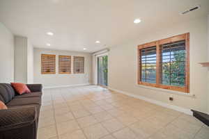 Living area featuring recessed lighting, light tile patterned flooring and walk out.