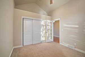 Bedroom with lofted ceiling, carpet floors, ceiling fan, and closet.