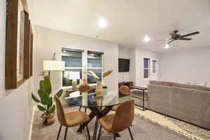 Carpeted dining area with ceiling fan