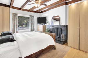 Bedroom with beam ceiling, light wood-style floors, and ceiling fan