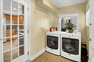 Laundry room with light tile patterned floors and independent washer and dryer