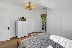 Bedroom with carpet flooring, a chandelier, and access to exterior