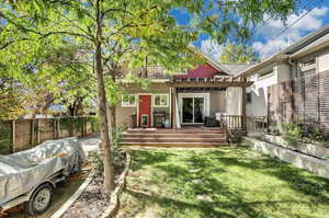 Rear view of house with a fenced backyard, a wooden deck, and a pergola