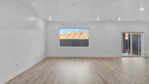 Empty room featuring light wood-style floors and recessed lighting