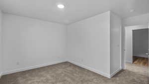 Empty room featuring carpet floors and baseboards