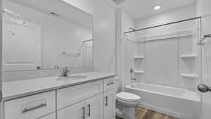 Full bath with vanity, shower / bath combination, and dark wood-type flooring