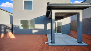 Property entrance with stucco siding and a patio