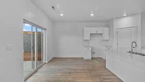 Unfurnished dining area with light wood-style flooring and recessed lighting