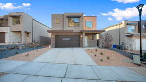 Contemporary house featuring stucco siding, driveway, stone siding, and an attached garage
