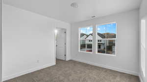 Carpeted spare room featuring baseboards