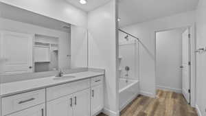 Full bathroom featuring shower / bathtub combination, vanity, dark wood finished floors, and recessed lighting