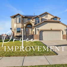 View of front of property featuring solar panels, brick siding, concrete driveway, and stucco siding