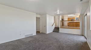 Empty room with carpet flooring and stairs