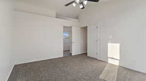 Unfurnished bedroom with carpet, a ceiling fan, high vaulted ceiling, and ensuite bathroom