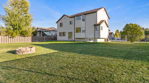 Back of house featuring a fenced backyard and an outdoor fire pit