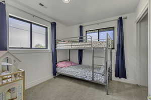 Bedroom featuring light carpet and baseboards