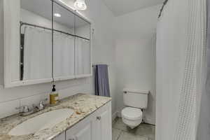 Bathroom with vanity, light tile patterned floors, and curtained shower