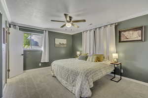 Bedroom featuring crown molding, light carpet, and a ceiling fan