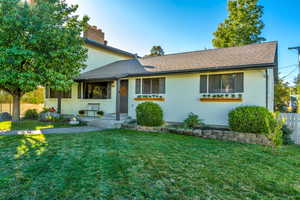 View of front of house with brick siding, roof with shingles, and a chimney