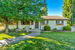 Single story home with a front yard, brick siding, and a shingled roof