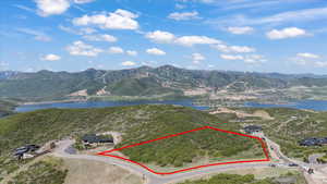 Aerial view of property and surrounding area featuring property parcel outlined and a water and mountain view