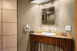 Bathroom featuring a textured wall and vanity