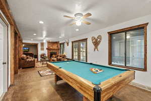 Game room featuring a ceiling fan, billiards, a textured ceiling, a fireplace, and recessed lighting