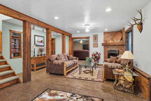 Living area featuring a fireplace, recessed lighting, and stairway